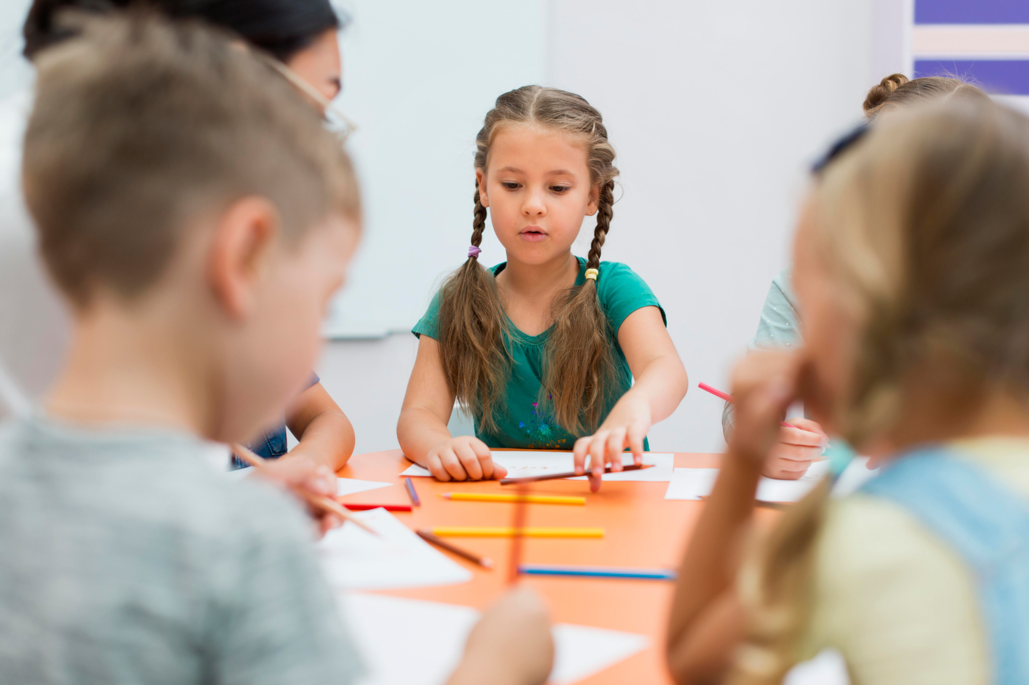 a group of kindergarteners listen to a teacher